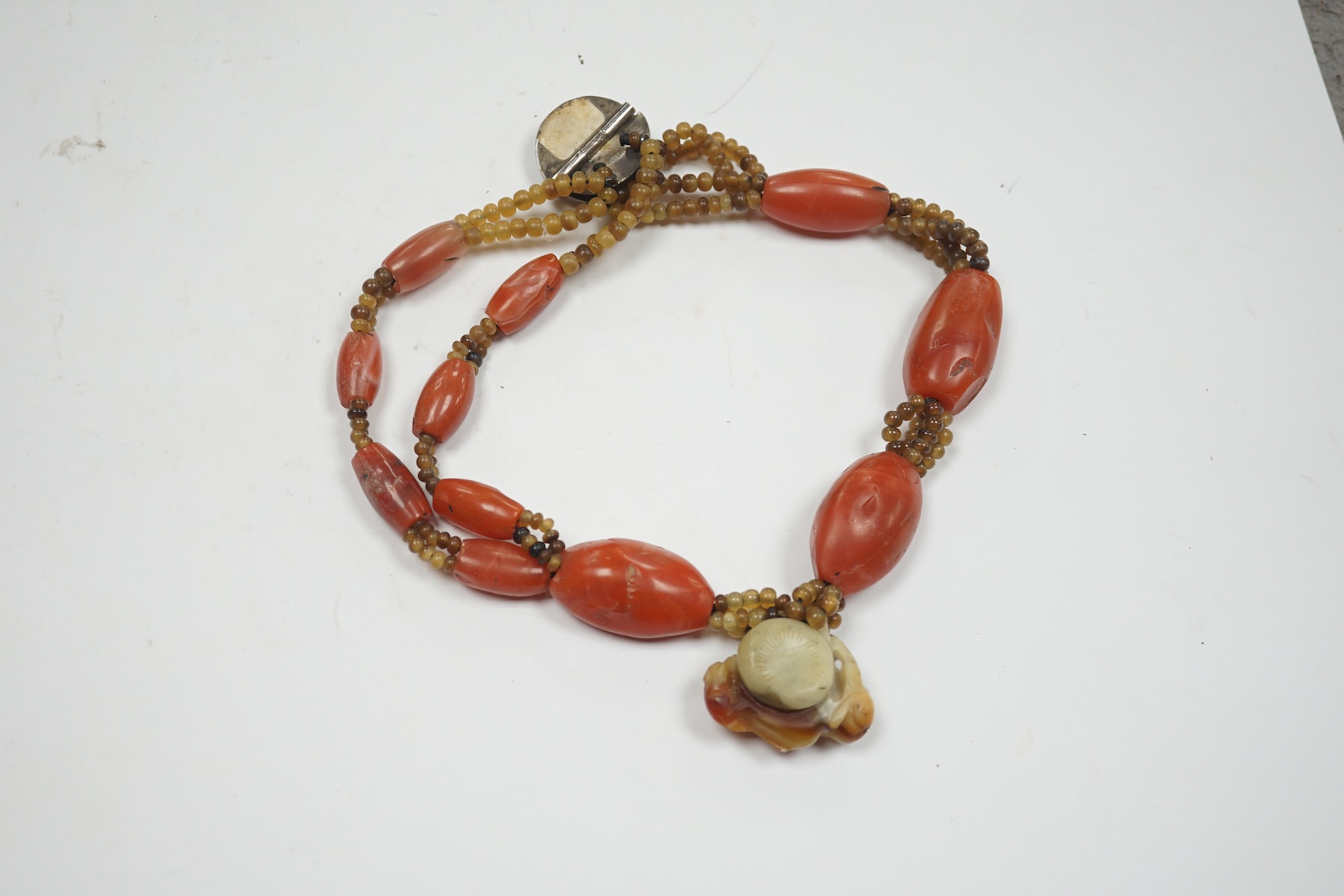 A mid 20th century Chinese chalcedony necklace, with carved pendant and sterling clasp, overall 54cm. Condition - poor to fair